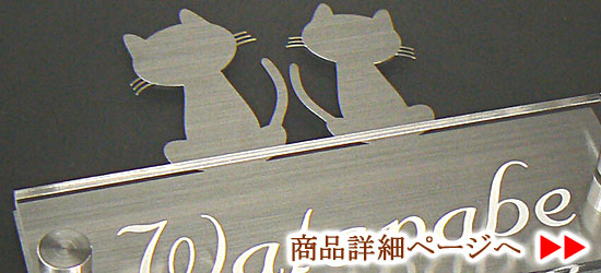 レーザーカットされたペアの猫を配置したステンレスプレートを背景にクリアプレートに彫刻された文字が浮かび上がる表札